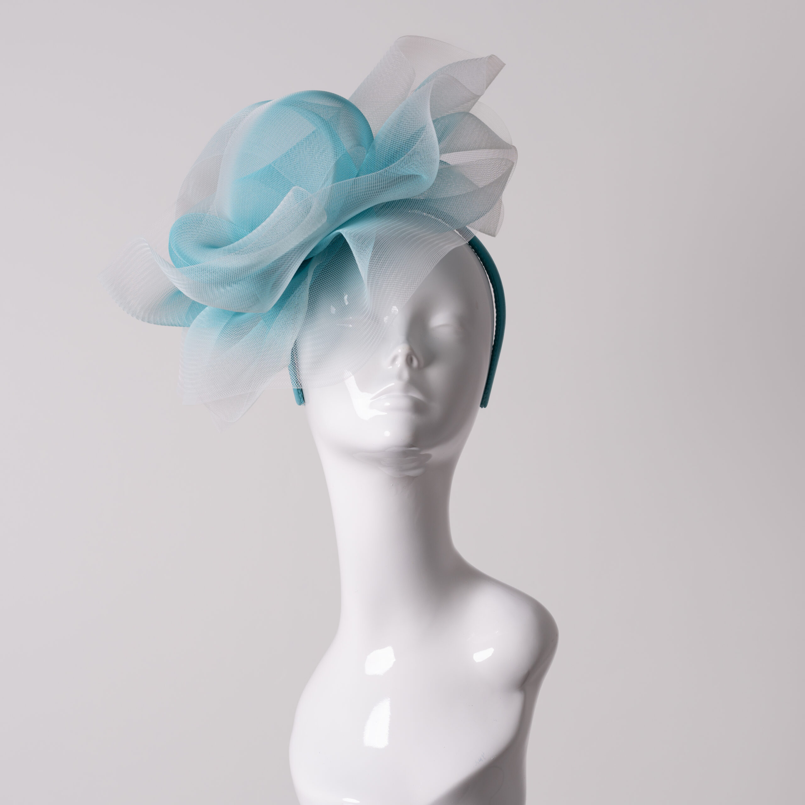 Aqua and white crin headpiece displayed on a white mannequin head